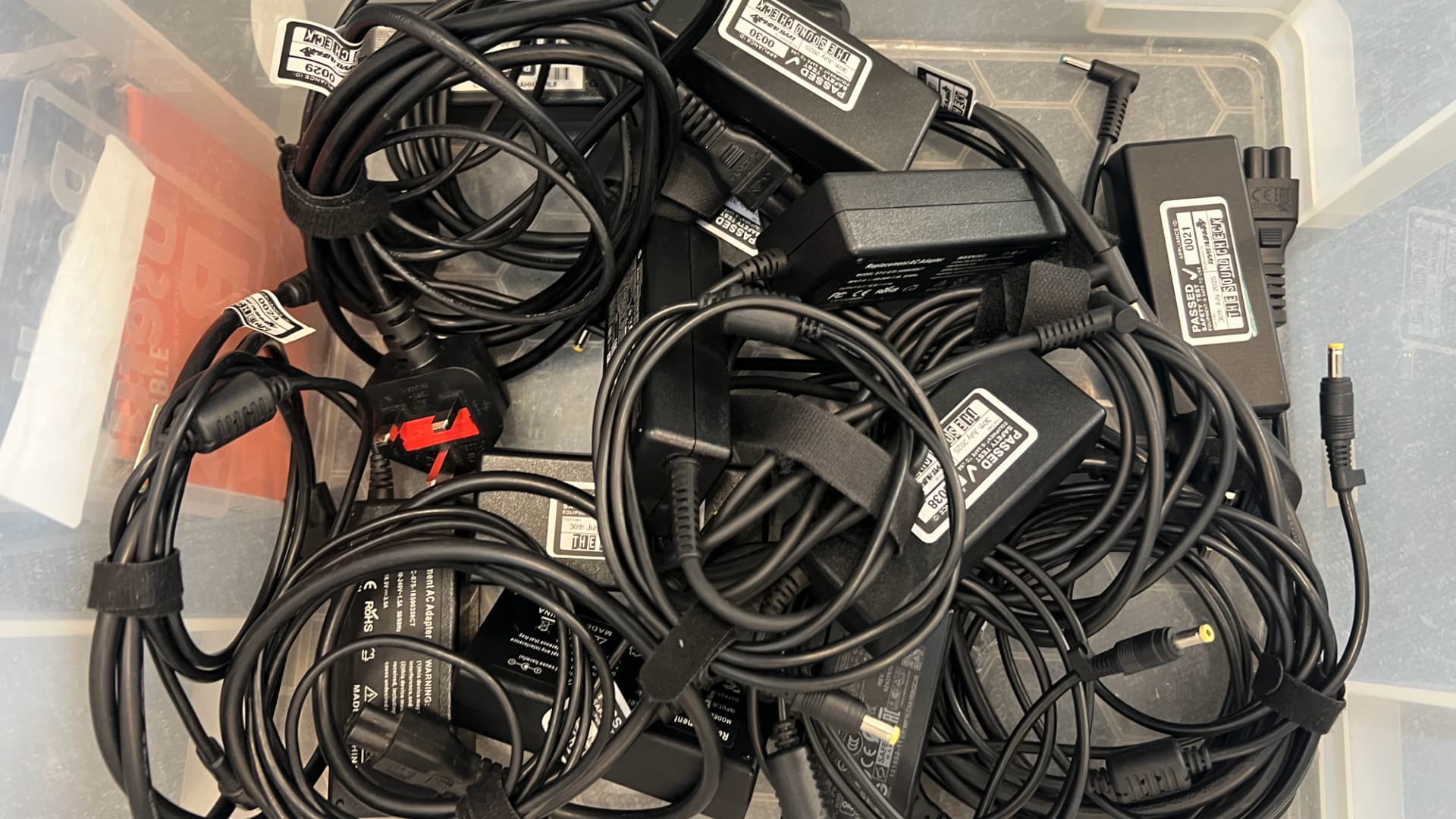 A collection of plugs and power leads prepared for testing